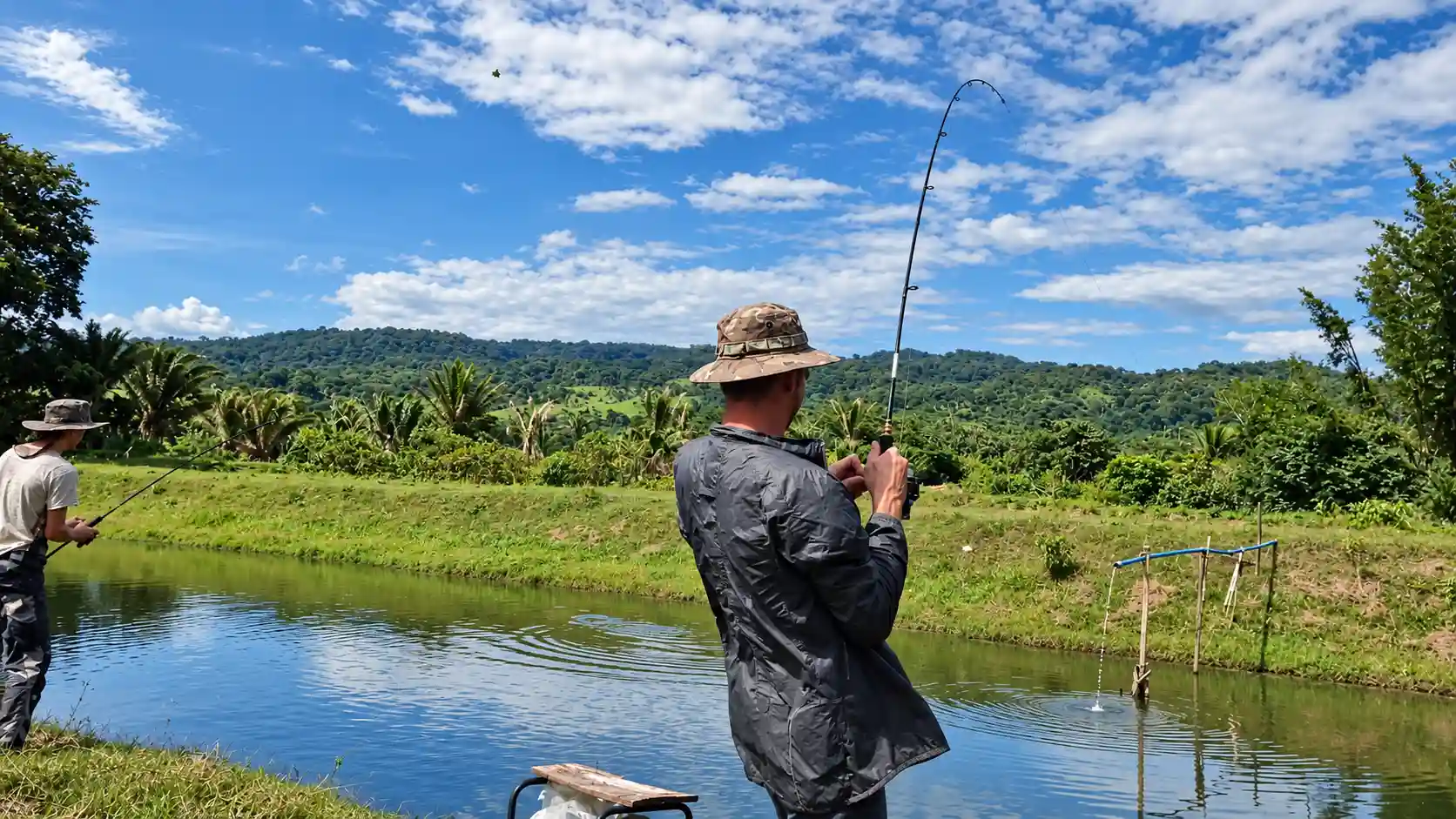 Fishing beside a pond in an open landscape