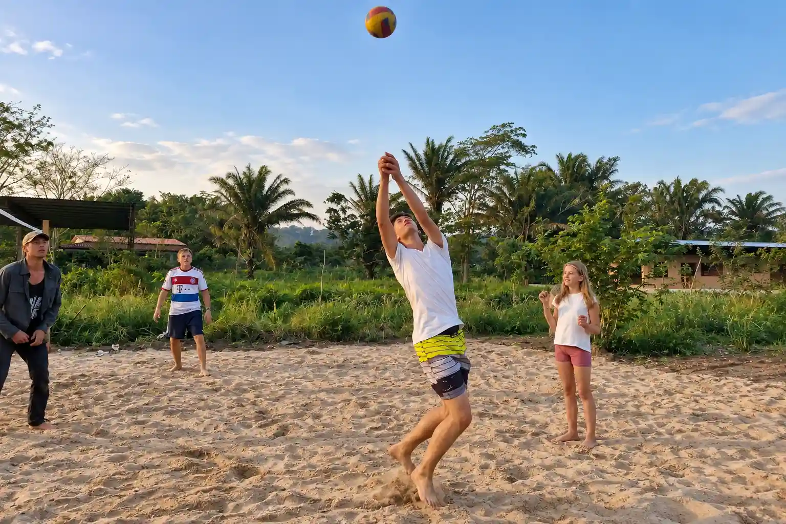 People playing volleyball together on a sand court